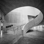 Black and white photo of a modern spiral staircase inside Tate Modern, London.